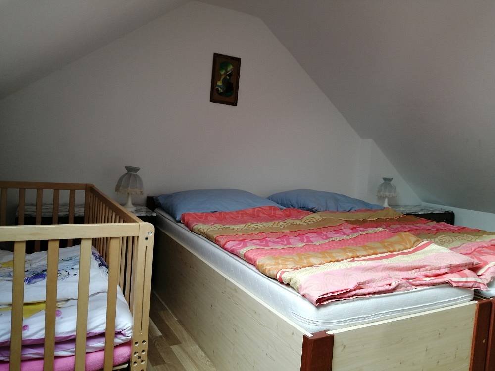 Podkrovní ložnice s dětskou postýlkou